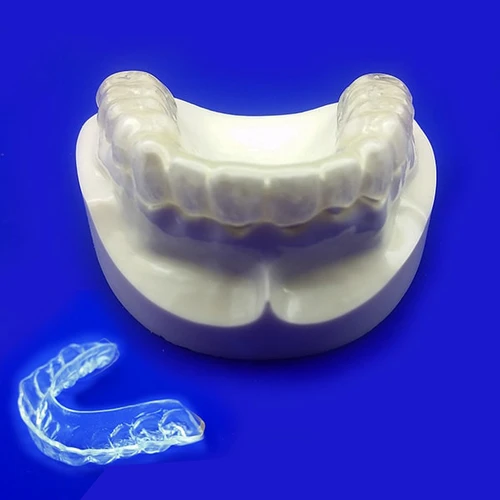 iHomeDental hard acrylic night guard shown on a dental model against blue background